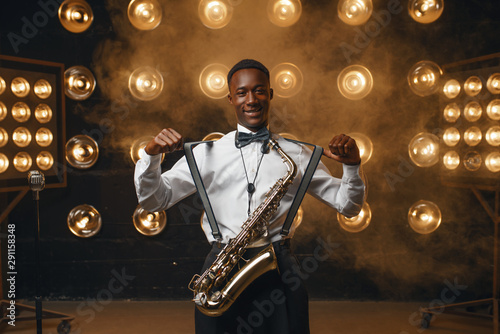 Smiling jazz performer with saxophone on stage