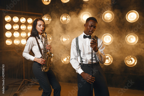 Male jazzman and female saxophonist with saxophone photo