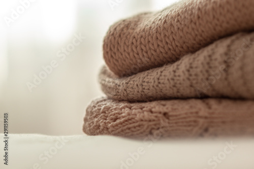 knitted warm pastel sweaters stacked, isolated, close-up