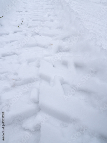 A closeup view of ATV or all terrain vehicle tracks in fresh white snow in Wisconsin.