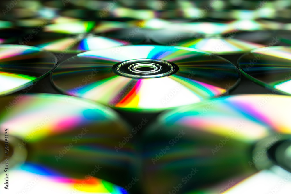 CDs / DVDs lying on a black background with colorful reflections of light. CDs / DVDs lying on a black background with colorful reflections of light.