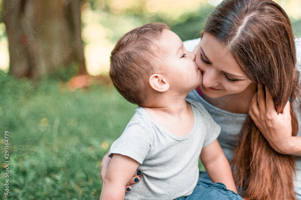 Little son kisses mother in the park. Little son kisses mother in the park.