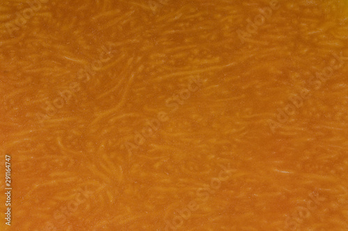 Yellow pumpkin cut in half with the texture of pulp. Pumpkin slices background closeup, top view