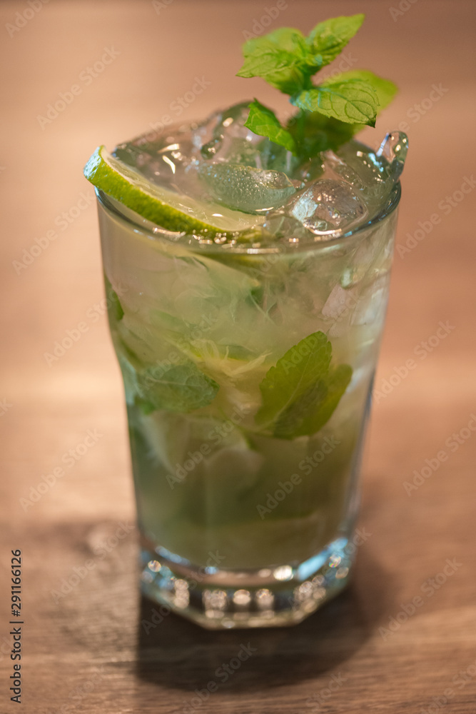 Refreshing mint cocktail mojito with rum and lime, cold drink or beverage with ice on white wooden background, top view Refreshing mint cocktail mojito with rum and lime, cold drink or beverage with ice on white wooden background, top view