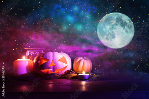 Fototapeta Naklejka Na Ścianę i Meble -  holidays image of halloween. Pumpkins over wooden table at night scary, haunted and misty forest