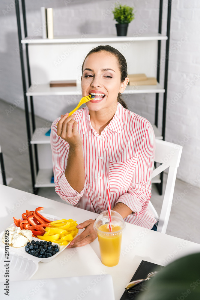 cheerful woman holding plastic fork with paprika cheerful woman holding plastic fork with paprika