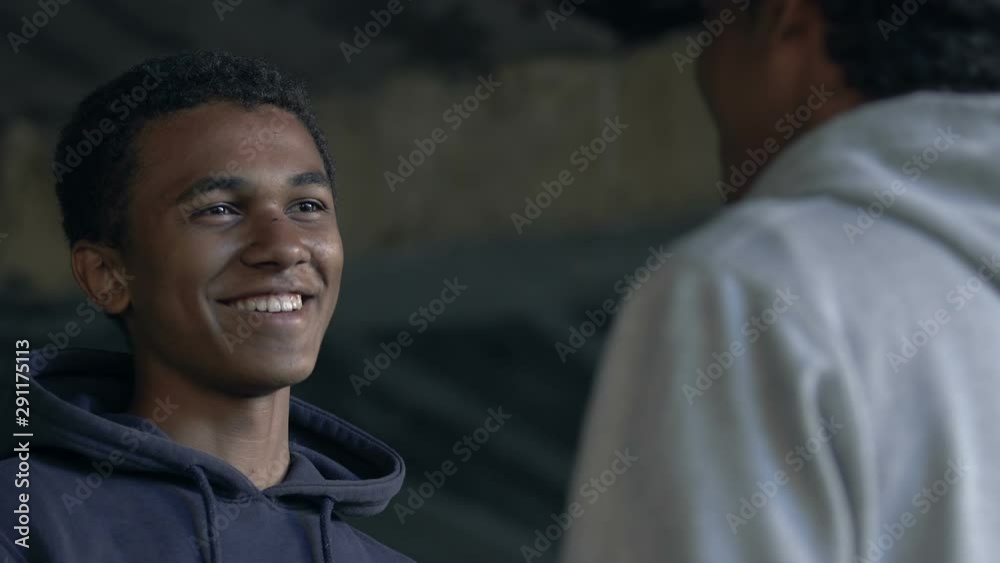 Two Afro-American male friends smiling and bumping fists, greeting gesture