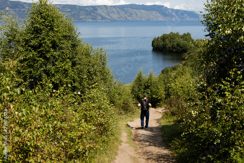 A tourist walking along the path leading to the Shaman Peninsula. Lake Baikal near the city of Slyudyanka photo