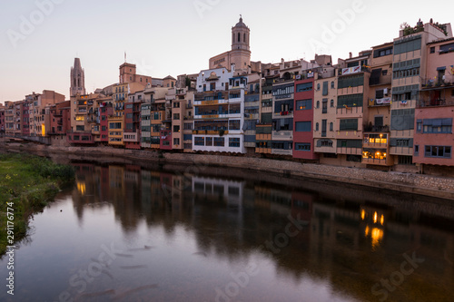 Colorful yellow and orange houses reflected in water river Onyar, in Girona, Catalonia, Spain.