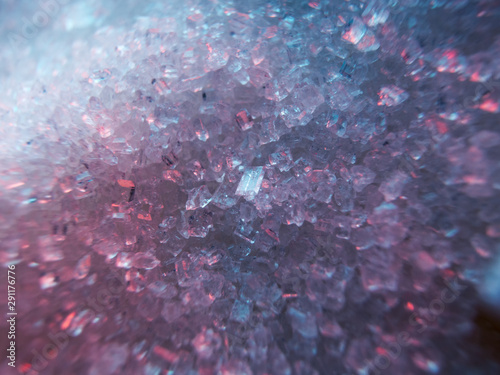 Heap of transparent white sugar crystals in mixed colour light. Macro photo photo