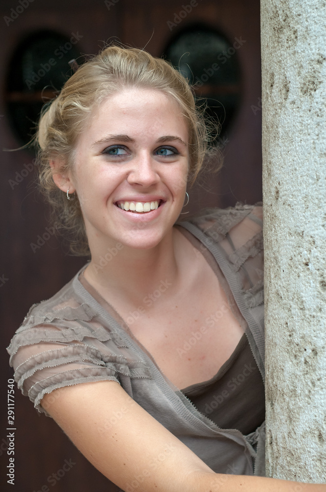 Fototapeta premium Young blonde girl photographed in the cloister of an old building
