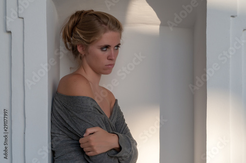 Young blonde girl photographed in the cloister of an old building