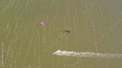 Kitesurfers ride on waves in the summer on the sea in windy weather, extreme water recreation
