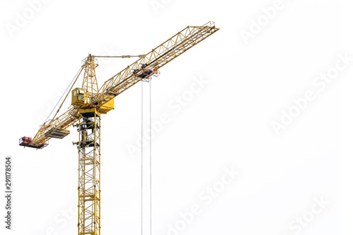 Yellow construction crane on a white isolated background builds multi-storey residential buildings using modern technologies of metal, concrete and brick according to the architectural design photo