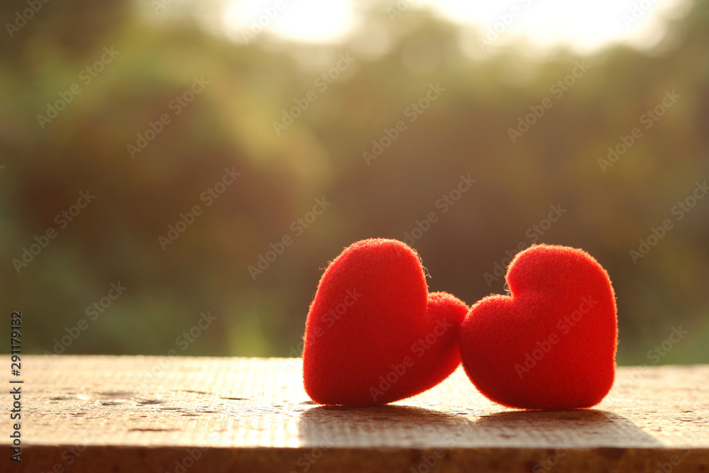 Two red pillow heart shape on wooden plate with sunlight, valentine day concept Two red pillow heart shape on wooden plate with sunlight, valentine day concept