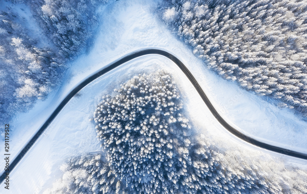 Aerial view on road and forest at the winter time. Natural winter landscape from drone. Winter - image - obrazy, fototapety, plakaty 