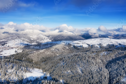 Aerial view at the winter mountains. Forest from air. Winter landscape from a drone. Snowy landscape. Aerial photography