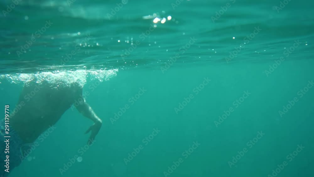 Swimming Man On Blue Sea Underwater.Underwater Man Swimming In Slow Motion With Air Bubbles.Air Bubbles In Water.Water Drops Falling And Splashing On Glassy Water Surface Blue Ocean. Swimming Man On Blue Sea Underwater.Underwater Man Swimming In Slow Motion With Air Bubbles.Air Bubbles In Water.Water Drops Falling And Splashing On Glassy Water Surface Blue Ocean.
