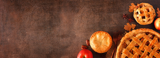 Homemade autumn apple pie corner border banner. Top view over a brown stone background with copy space.