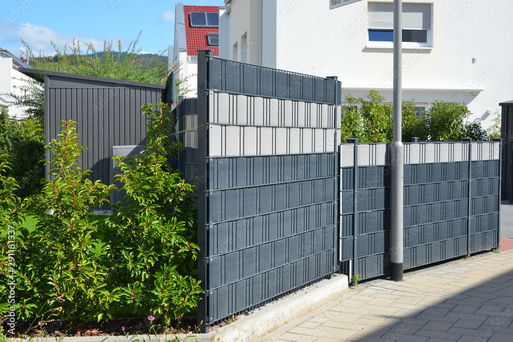 Verzinkter Stahlgitterzaun mit Kunststoff-Sichtschutzfolie als Einfriedung um den Garten eines Einfamilienhauses Verzinkter Stahlgitterzaun mit Kunststoff-Sichtschutzfolie als Einfriedung um den Garten eines Einfamilienhauses