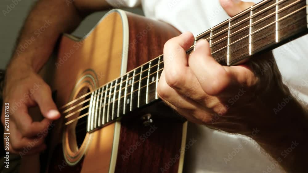 A man plays an acoustic guitar. The sun's rays Shine through the strings of a guitar. Music and hobbies. A man plays an acoustic guitar. The sun's rays Shine through the strings of a guitar. Music and hobbies.