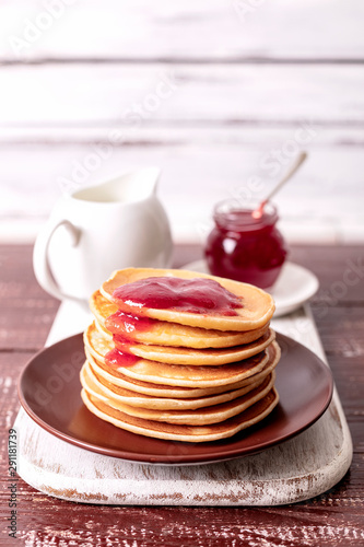 Tasty breakfast. Pancakes with strawberry confiture and butter.