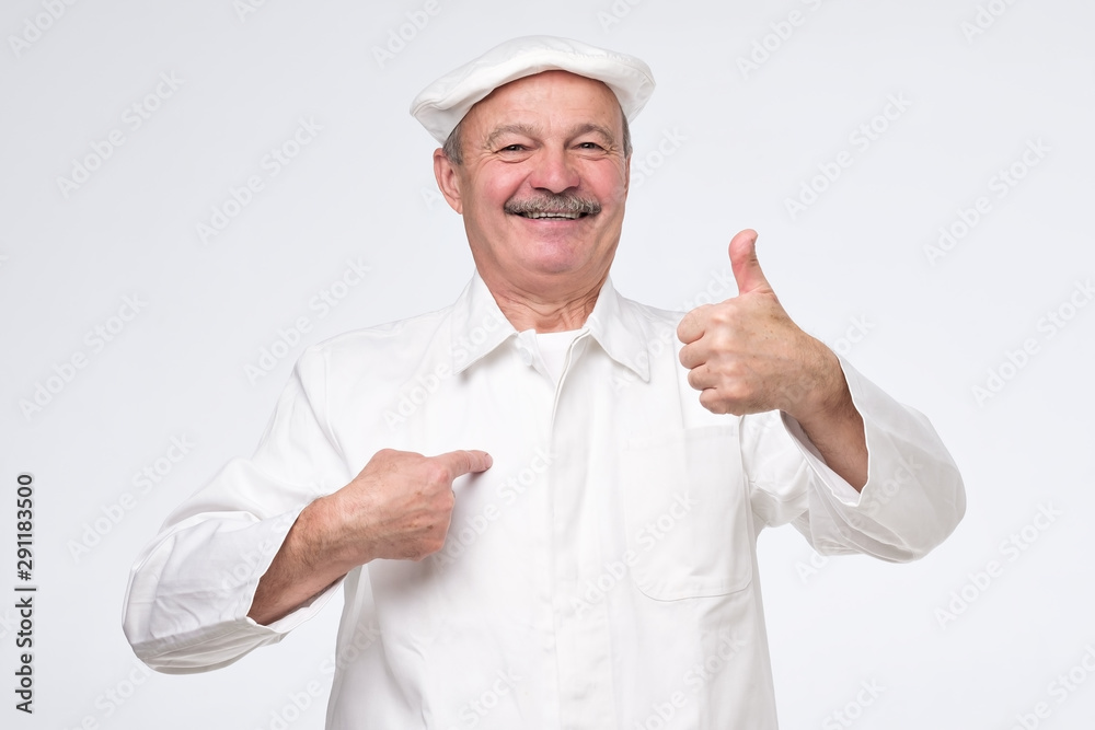 mature hispanic chef cook showing thumb up and pointing at his chest being proud on white background. Studio shot mature hispanic chef cook showing thumb up and pointing at his chest being proud on white background. Studio shot