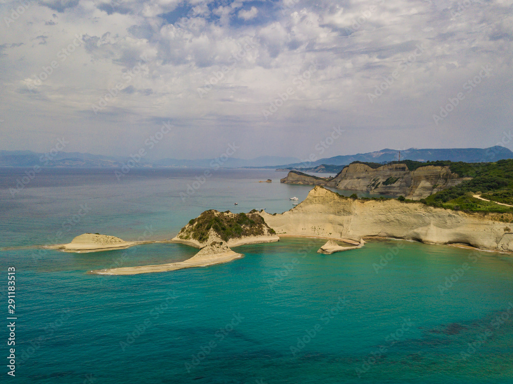 Aerial photo of iconic white rock steep cliff volcanic bay of Cape Drastis and Peroulades area with tropical deep turquoise clear sea. Photo from drone. Corfu island, Ionian, Greece Aerial photo of iconic white rock steep cliff volcanic bay of Cape Drastis and Peroulades area with tropical deep turquoise clear sea. Photo from drone. Corfu island, Ionian, Greece