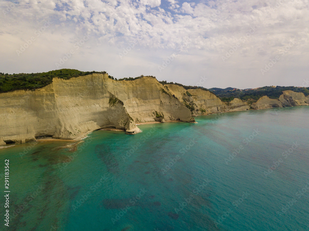 Aerial photo of iconic white rock steep cliff volcanic bay of Cape Drastis and Peroulades area with tropical deep turquoise clear sea. Photo from drone. Corfu island, Ionian, Greece