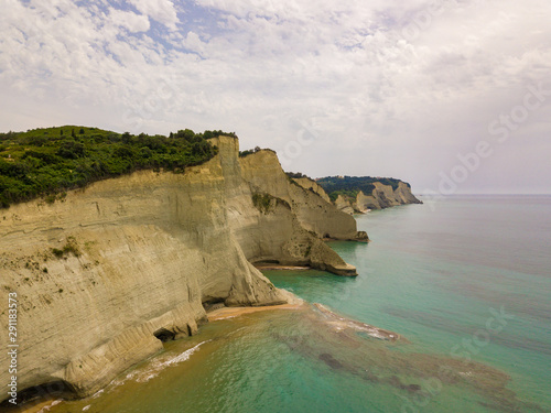 Aerial photo of iconic white rock steep cliff volcanic bay of Cape Drastis and Peroulades area with tropical deep turquoise clear sea. Photo from drone. Corfu island, Ionian, Greece