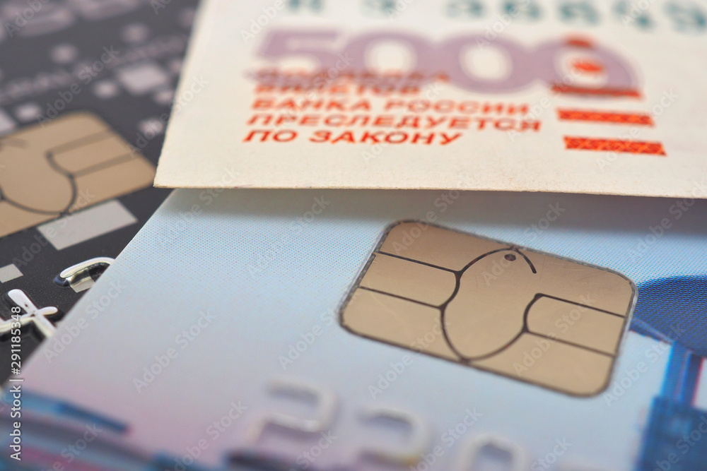 Bank cards and a fragment of a banknote of 5000 rubles. Payment system Mir. Close-up Bank cards and a fragment of a banknote of 5000 rubles. Payment system Mir. Close-up
