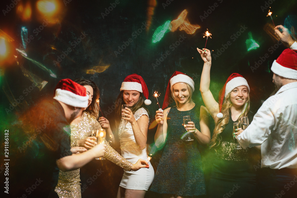 Christmas, dance party in night club, holiday, fun. Happy people celebrating New Year together. Company of friends in Santa caps dancing, celebration in motion Christmas, dance party in night club, holiday, fun. Happy people celebrating New Year together. Company of friends in Santa caps dancing, celebration in motion