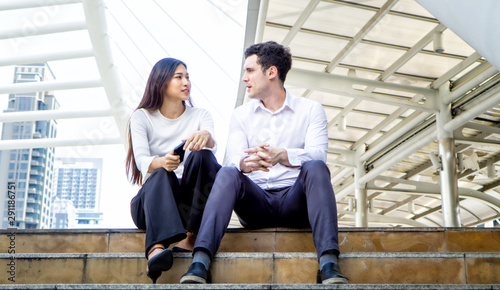 young business people sitting on step outdoor