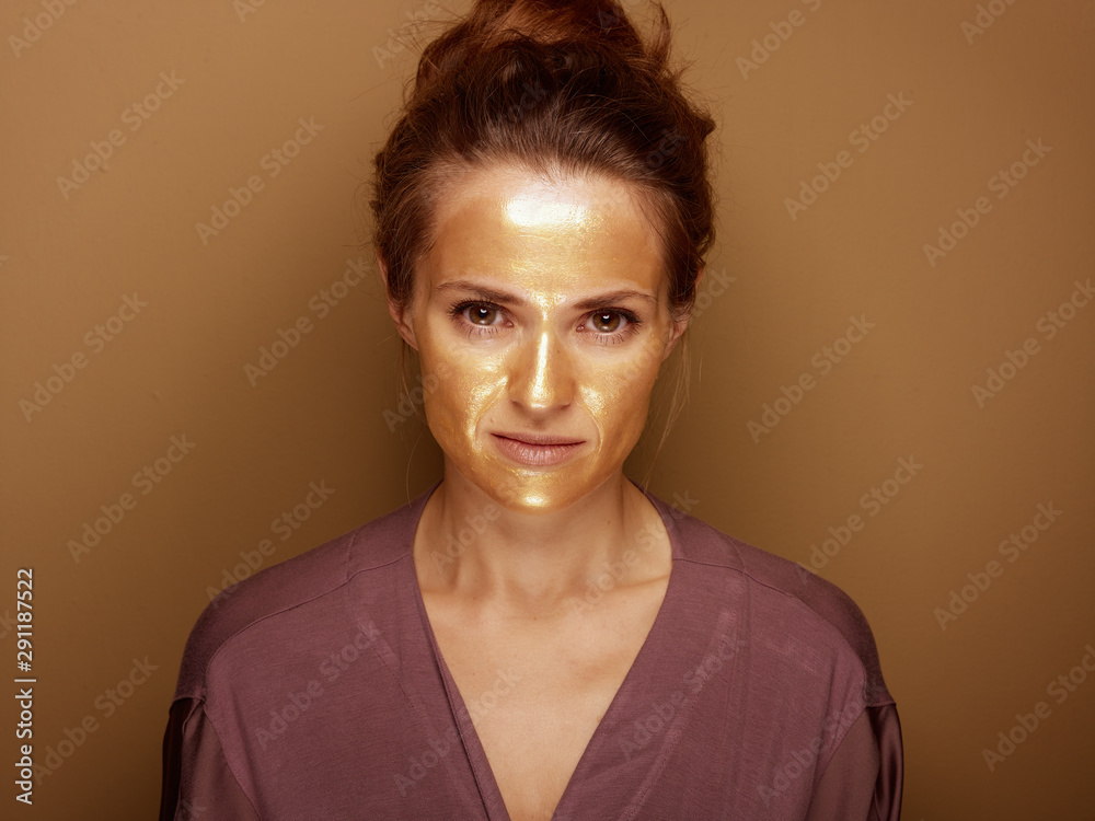Fototapeta premium modern housewife with golden mask isolated on beige