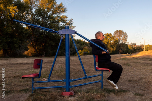 Middle Age Man Making Exercise in Outdoor Gym in The Evening