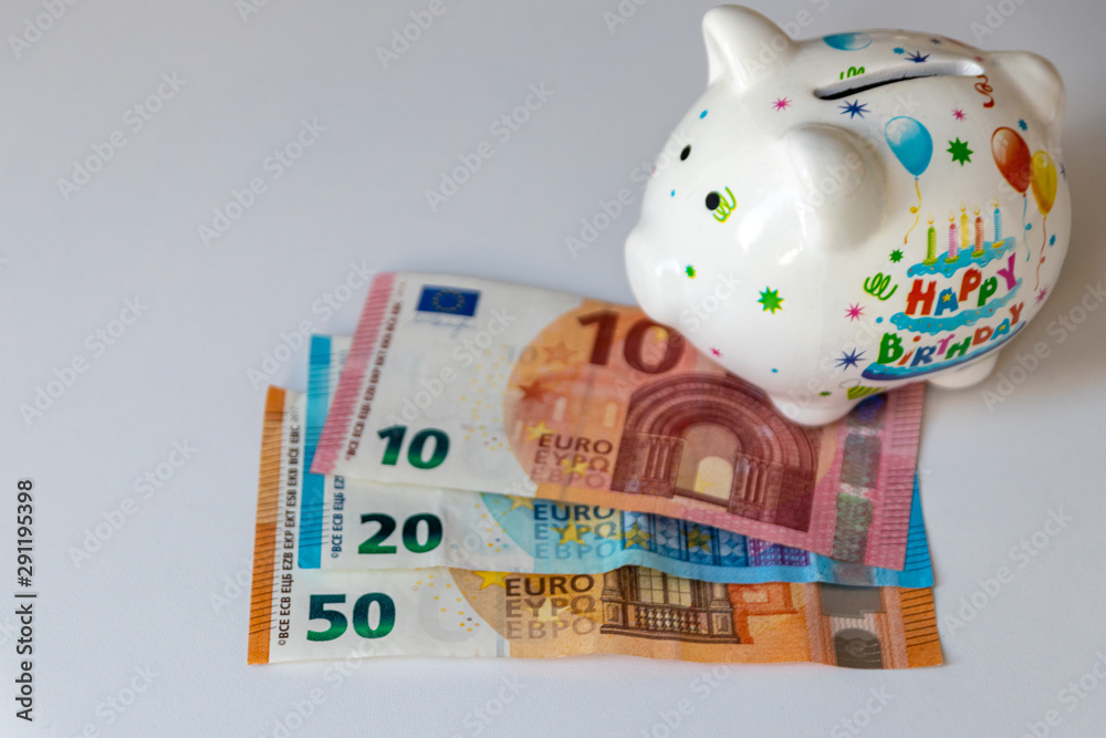 Weißes Sparschwein mit Aufschrift Happy Birthday und EUROGeldscheinen