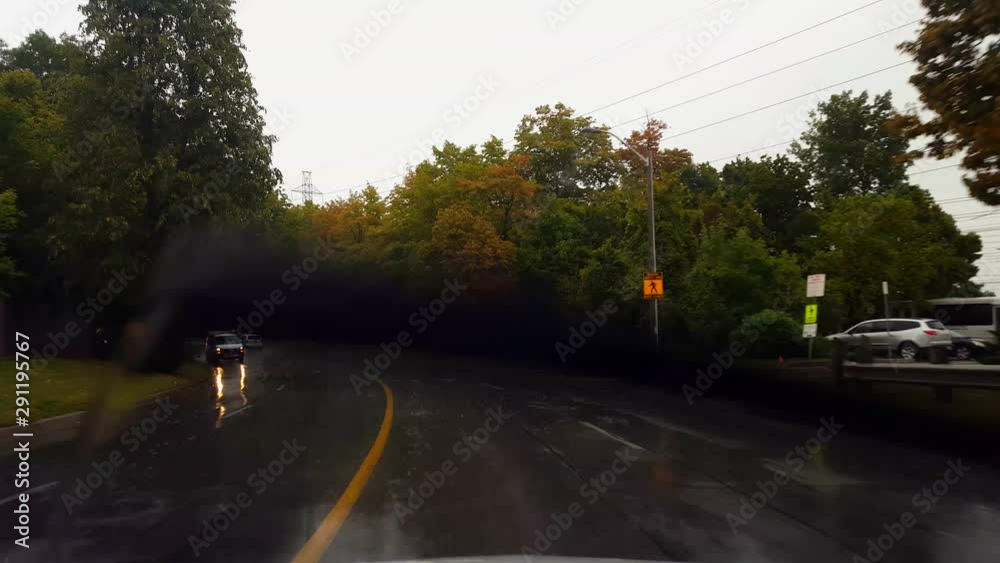 Driving Rain City Street Under Overcast Sky in Summer Day. Driver Point of View POV Raining Urban Wet Road With Windshield Wipers. Driving Rain City Street Under Overcast Sky in Summer Day. Driver Point of View POV Raining Urban Wet Road With Windshield Wipers.
