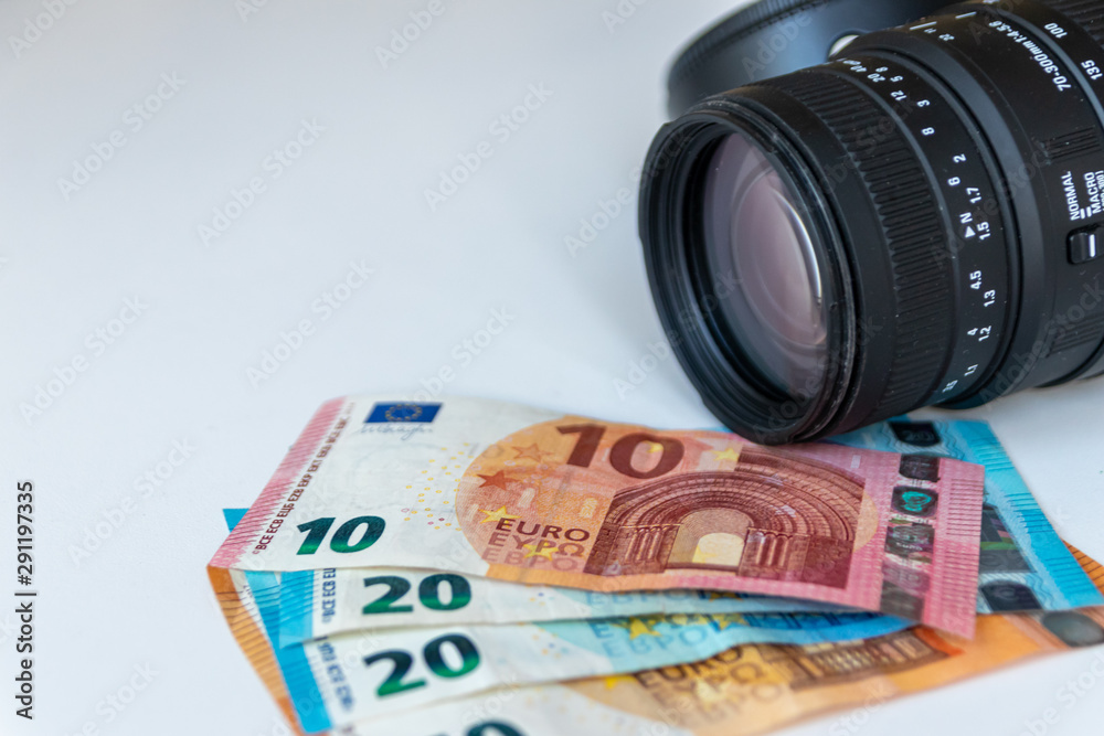 70-300mm Zoom-Objektiv mit Gegenlichtblende und Geldscheinen 10 EUR, 20 EUR und 50 EUR zeigt das Hobby Fotografie und seine Foto-Kosten aber auch Geld verdienen mit Stock-Fotografie
