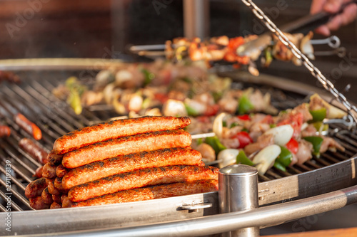 Sausages and vegetables are grilled outdoors