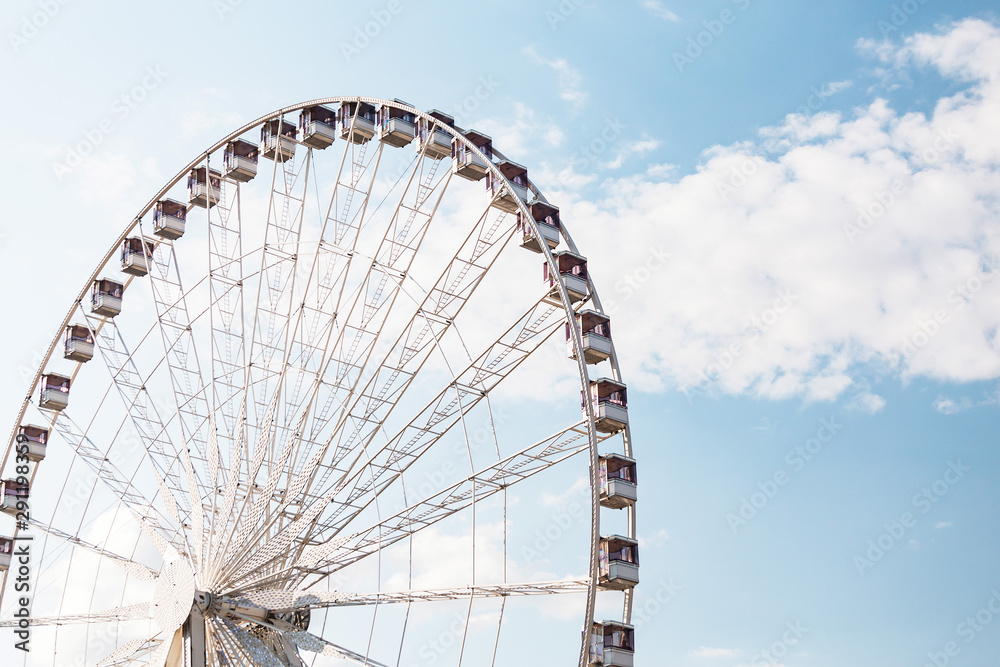 Ferris wheel close-up against blue sky background