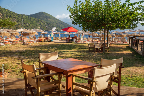 Fototapeta Naklejka Na Ścianę i Meble -  Beautiful summer calm morning empty table chairs in Antisamos beach bar, Kefalonia island, Ionian sea, Greece.