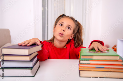 is upset to read two large stacks of books lying next to her on the table