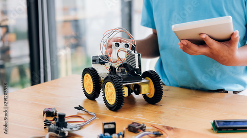Tableau sur toile Boy with tablet pc computer programming electric toys and building robots