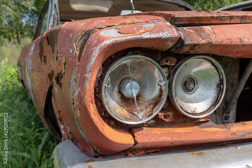 Headlight of an old rusty abandoned car, utilisation and scrap concept