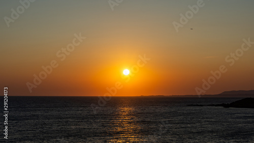 orange greek sunset on beach © alister