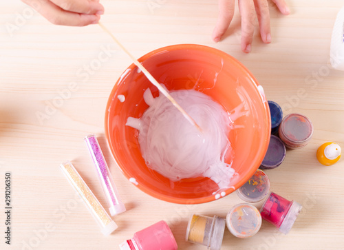 Slime making process. Girl making slime, worldwide popular self made toy. photo