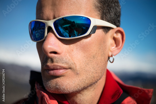 man with sunglasses on the mountains in a beautiful sunny day