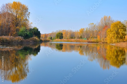 Water Reflected Autumn Colors With Blue Sky