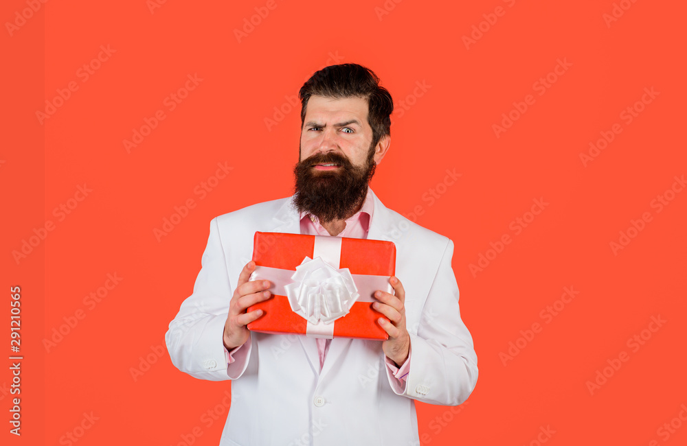 Bearded man holds gift box. Valentine's day, christmas, new year, birthday and holidays concept. Handsome man with christmas gift. Attractive man with gift. Businessman holds gift box. Copy space.