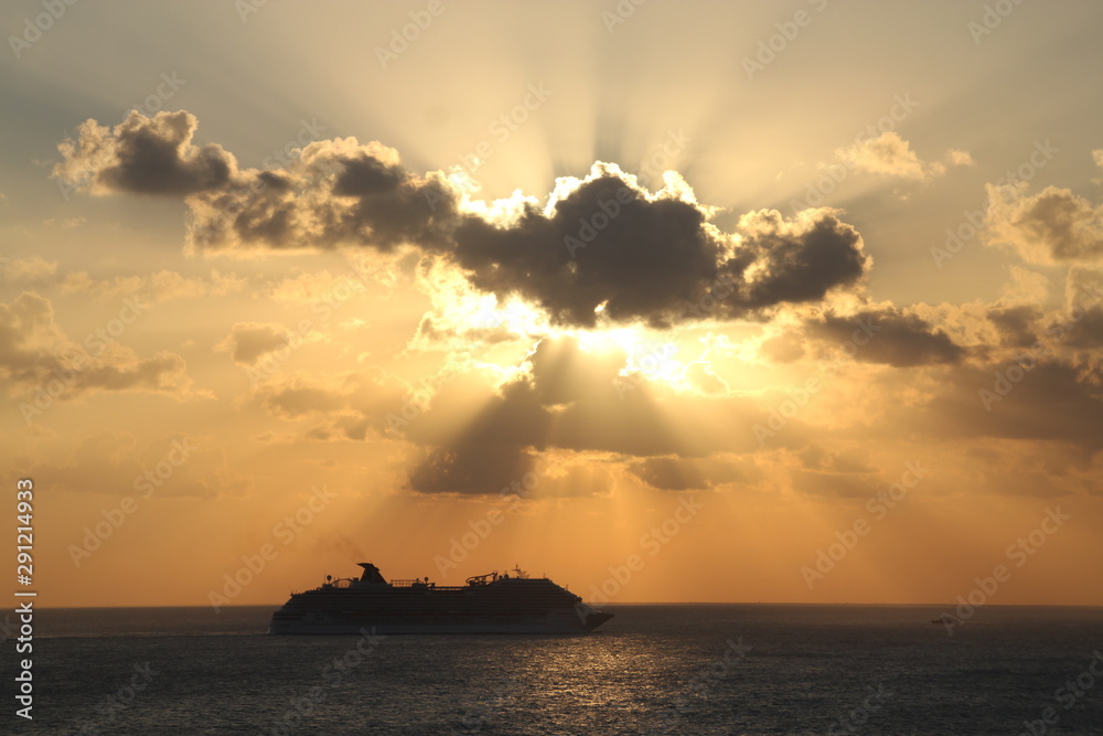 Sun beans over cruise ship in the sea